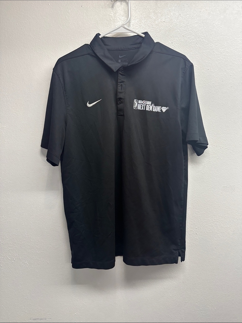 Nike Menโs Black Polo with White Swoosh and NBA Next Gen Logo